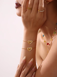 Détail du bracelet MAMMA en cœur doré avec sertissage en zircons sur poignet féminin