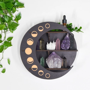 Detail of black crescent moon wooden shelf with hollow phase design and three tiers