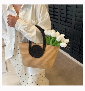 Detail of beige woven cotton rope tote bag with black circular patterns and tulip accent