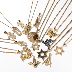 Gros plan de pendentifs hip hop plaqués or avec main de Fatma et divers motifs punk rock
