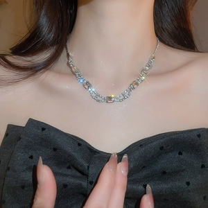 Detailed view of silver necklace featuring square and rectangular rhinestones on a model