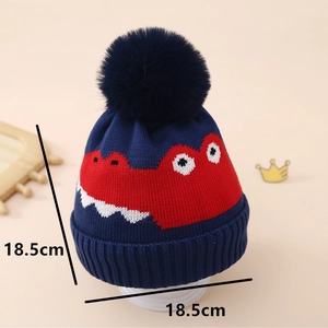 Détail du bonnet en tricot dinosaure pour enfant avec motif rouge et pompon bleu