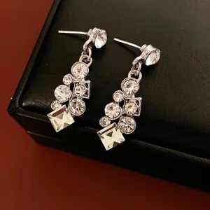 Silver geometric diamond stud earrings set on black leather case with a luxury finish