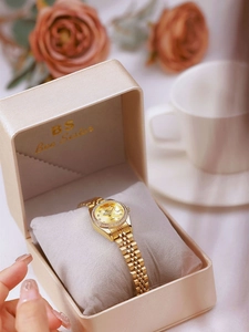Detail of luxury gold women's quartz watch with crystal bezel in premium display box
