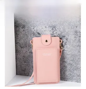 Detail of pink leather phone bag with gold snap closure and brand lettering