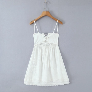 Detail of white lace mini dress featuring back lace-up design and eyelet embroidery details