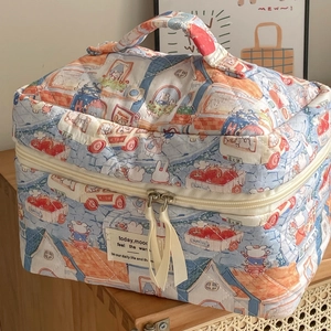 Detail of quilted cosmetic bag with hand-drawn rabbit patterns and double ribbon zippers