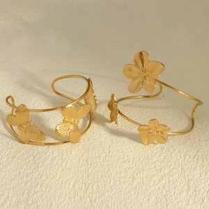Elegant 18k gold plated stainless steel flower bangles set on a textured surface