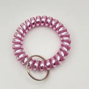 Detail of a bright pink metallic spiral wristband keyring with a silver metal ring
