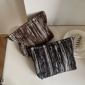 Detail shot of vintage denim-feel striped cosmetic bags with zipper closure and woven texture