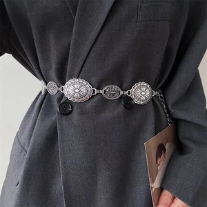 Detail of vintage silver metal waist chain with embossed circular links on a suit