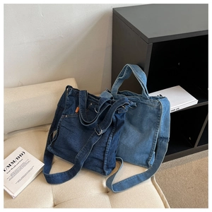 Detailed shot of large denim tote bags in light and dark blue with metal hardware