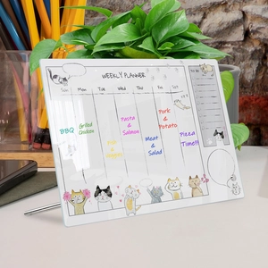 Macro detail of acrylic weekly planner board with cat illustration and silver support stand
