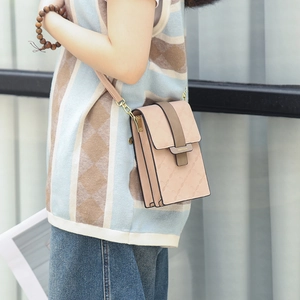 Bolso rosa para móvil con diseño de cuadros y correa marrón llevado por modelo