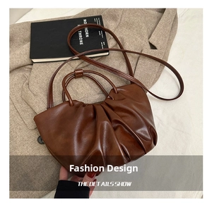 Detail view of dark brown pleated cloud bag with soft faux leather texture and straps