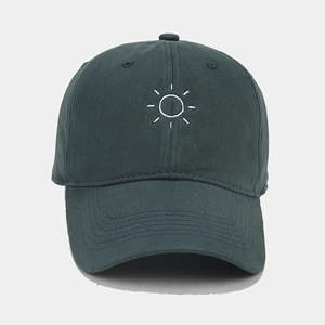 Detail of sun embroidery on a dark green soft cotton baseball cap with ventilation holes
