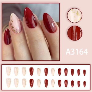 Almond shaped plum red and pink press-on nails set with gold foil accents and 24 pieces