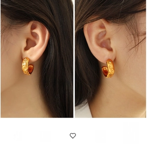 Close-up of golden earrings with celestial sun and moon relief patterns on model