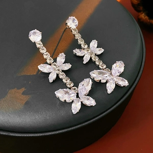 Détail de boucles d'oreilles papillon en argent avec zircons sur un support noir