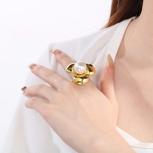 Dettaglio di un grande anello a fiore placcato oro 18K con perla bianca sulla mano