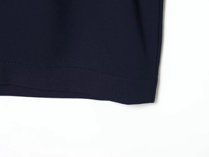 Détail de l'ourlet d'une robe midi bleu foncé montrant la texture fine du tissu sergé