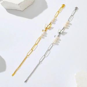 Macro view of butterfly charms and freshwater pearls on gold and silver chain bracelets