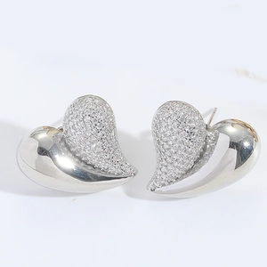 Detailed macro view of heart-shaped earrings featuring asymmetric micro-pave cubic zirconia
