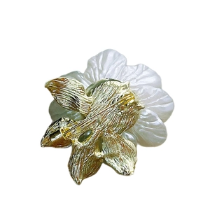 Back view of pearl camellia brooch showing gold-plated safety pin and metal structure
