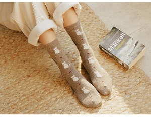 Close-up of cozy brown wool blend mid-calf socks with cute cat and red heart patterns