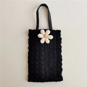 Detail of black bubble texture car tissue holder with a white daisy floral accent