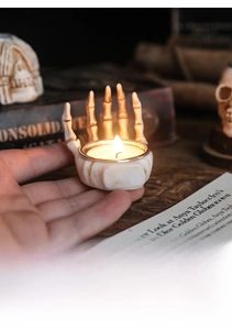 Detailed view of skull hand candle holder with burning tealight for Halloween decor
