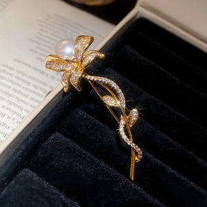 Macro detail of vintage floral brooch with sparkling zircons and a white pearl accent