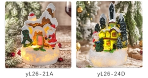Close-up of lighted resin Christmas house ornaments featuring Santa Claus and snow