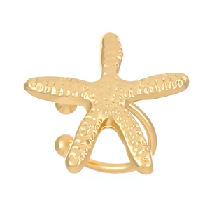 Close-up of golden starfish ear cuff with detailed metallic texture on white background