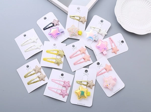 Detailed close-up of glitter and holographic star-shaped hair clips on display cards