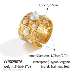 Détail d'une bague en acier inoxydable doré avec texture martelée et perle fine