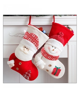 Detail of red and white knitted Christmas stockings with Santa and snowman motifs