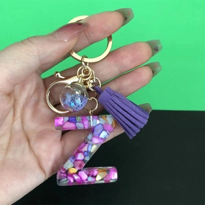 Detail of resin letter Z keychain with colorful stones, purple tassel and gold hardware