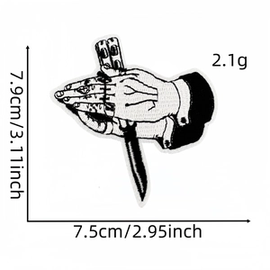 Macro view of punk style black and white embroidered patch with hands and knife design