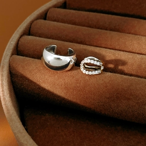 Detail view of 18k gold plated cuff earrings with cubic zirconia on brown velvet