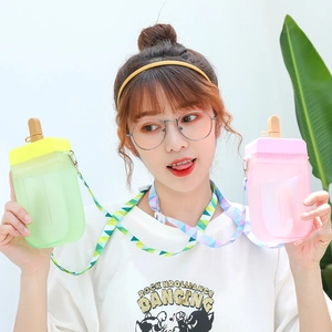 Detailed view of pink and green popsicle-shaped water bottles with straws and colorful straps