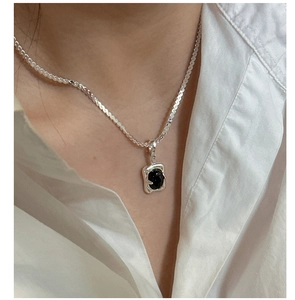 Close-up of S925 sterling silver necklace with black agate pendant on model
