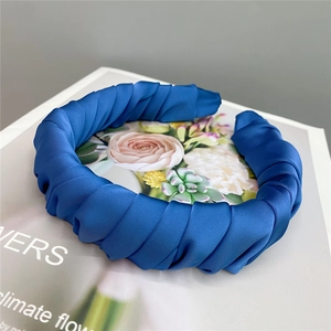 Macro detail of blue pleated satin headband showing smooth silk fabric texture and pleats