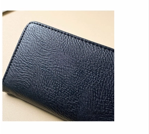 Dettaglio della texture in pelle blu scuro e delle cuciture precise sul portafoglio lungo