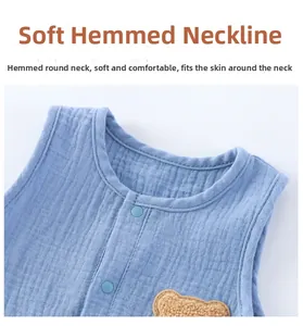 Detail of baby light blue muslin bodysuit with press studs and cute bear embroidery