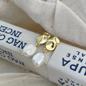 925 silver irregular baroque pearl earrings in gold finish on minimalist background