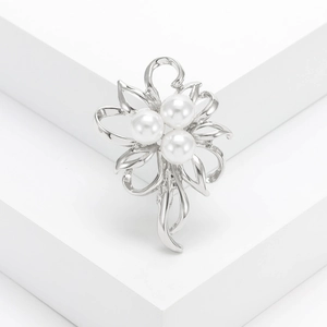 Elegant floral silver brooch with white pearls and hollow leaf design on white stand