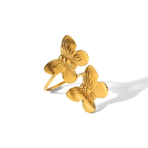 Detailed macro shot of twin golden butterfly ring with textured wings on white background