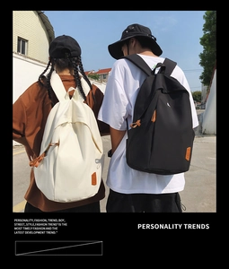 Outdoor street style view of black and cream white large capacity school backpacks