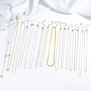Assortimento di collane in acciaio inossidabile placcato oro 18K su raso bianco